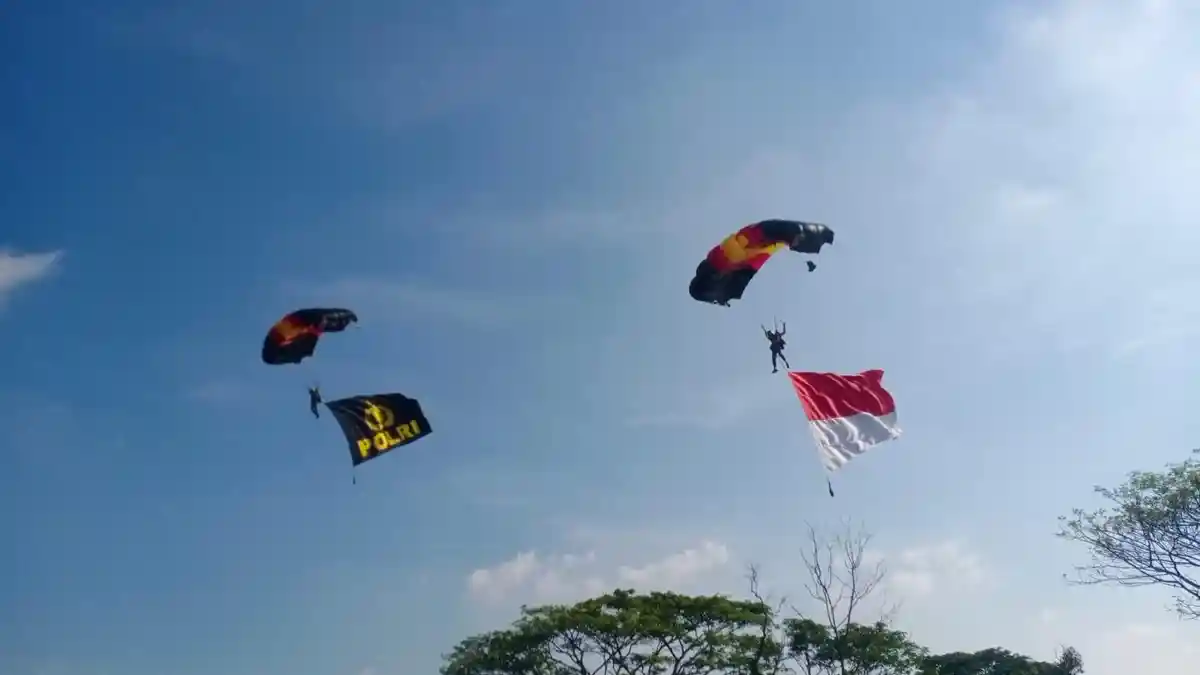 AKSI Anggota Brimob Terjun Payung Bentangkan Bendera Merah Putih dan Tribrata di Langit Indramayu