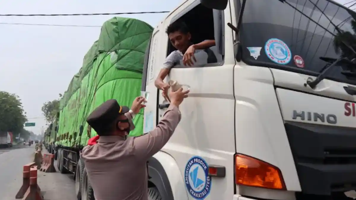 Macet 9 Km di Pantura Gresik, Kapolsek Manyar Bagikan Makanan dan Minuman kepada Sopir Truk