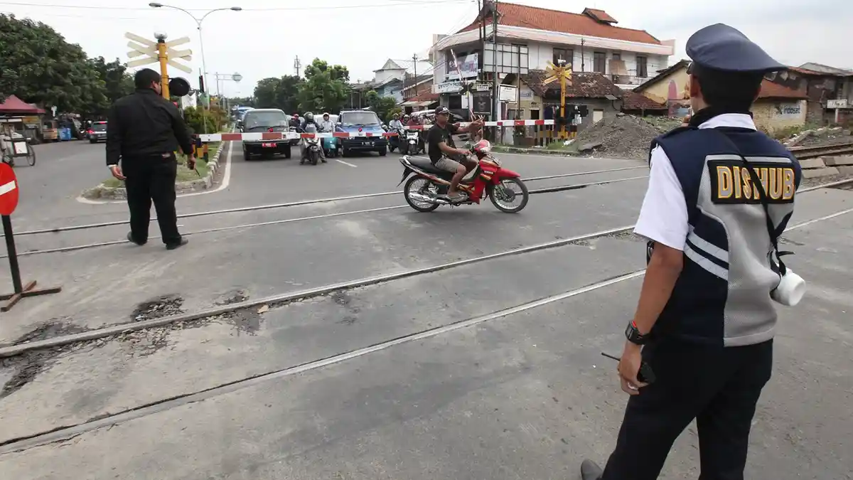 FOTO: Bandelnya Pengendara di Kota Bandung, Terobos Palang Kereta Api Tanpa Helm dan Plat Motor