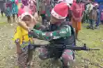 Sambut Natal, Satgas Yonif Raider 142/KJ Bagikan Topi Santa