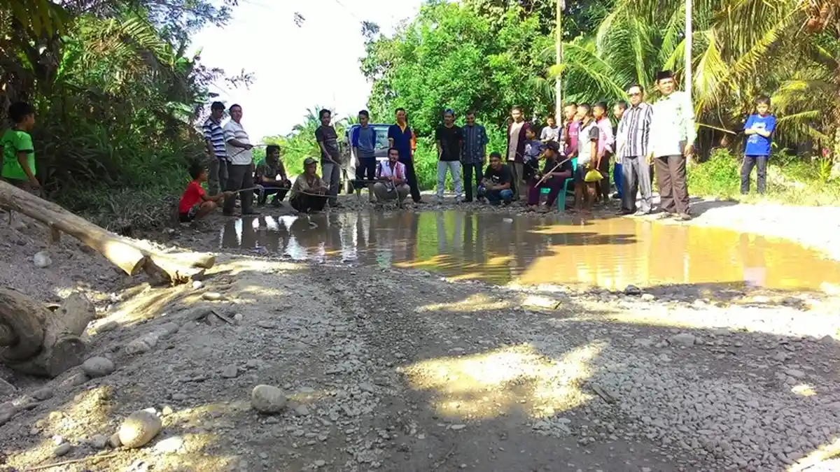 Warga Rohul Gelar Lomba Memancing di Kubangan Jalan Rusak