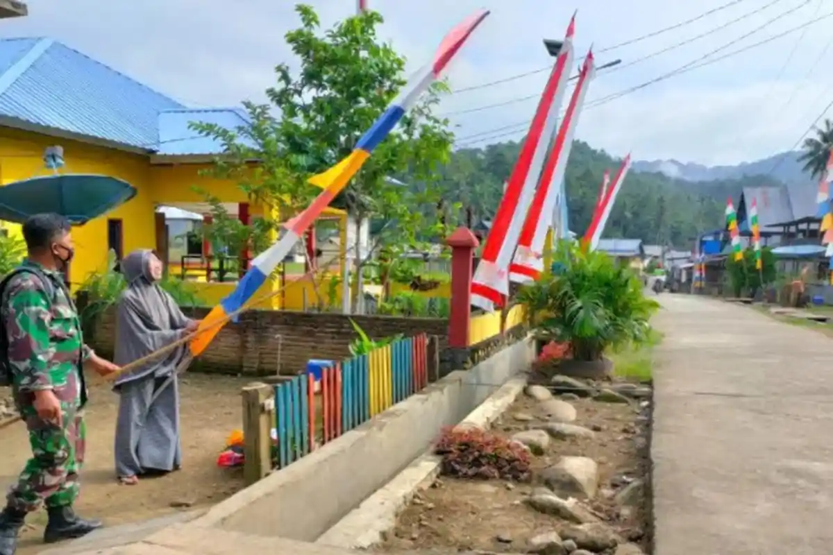 Babinsa Turun ke Desa Ajak Warga Wonomulyo, Polman Pasang Bendera Merah Putih
