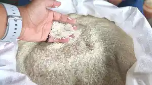 Seorang-pedagang-memperlihatkan-beras-yang-ia-jual.jpg