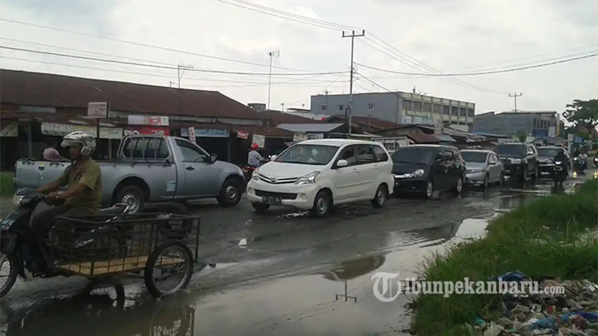 FOTO: Jalan Garuda Sakti Rusak dan Digenangi Air, Pengendara Berusaha Hati-hati - jalan_rusak_garuda_sakti_1_06052016_20160506_154305.jpg