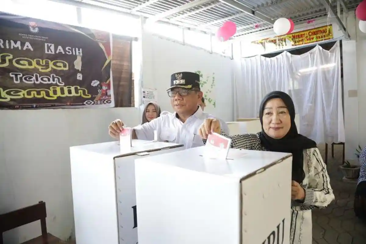 Pj Wali Kota Kotamobagu dan Ketua TP PKK Memilih di TPS 7 Kotobangon, Ajak Gunakan Hak Suara