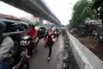 Pejalan Kaki Melintas di Trotoar Proyek Perbaikan Saluran