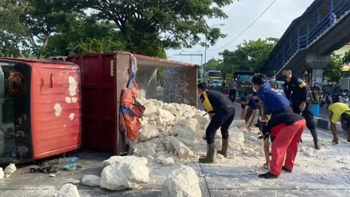 Pecah Ban, Truk Muatan Batu Putih Terguling di Kedung Cowek Surabaya, Sempat Oleng Senggol Pemotor