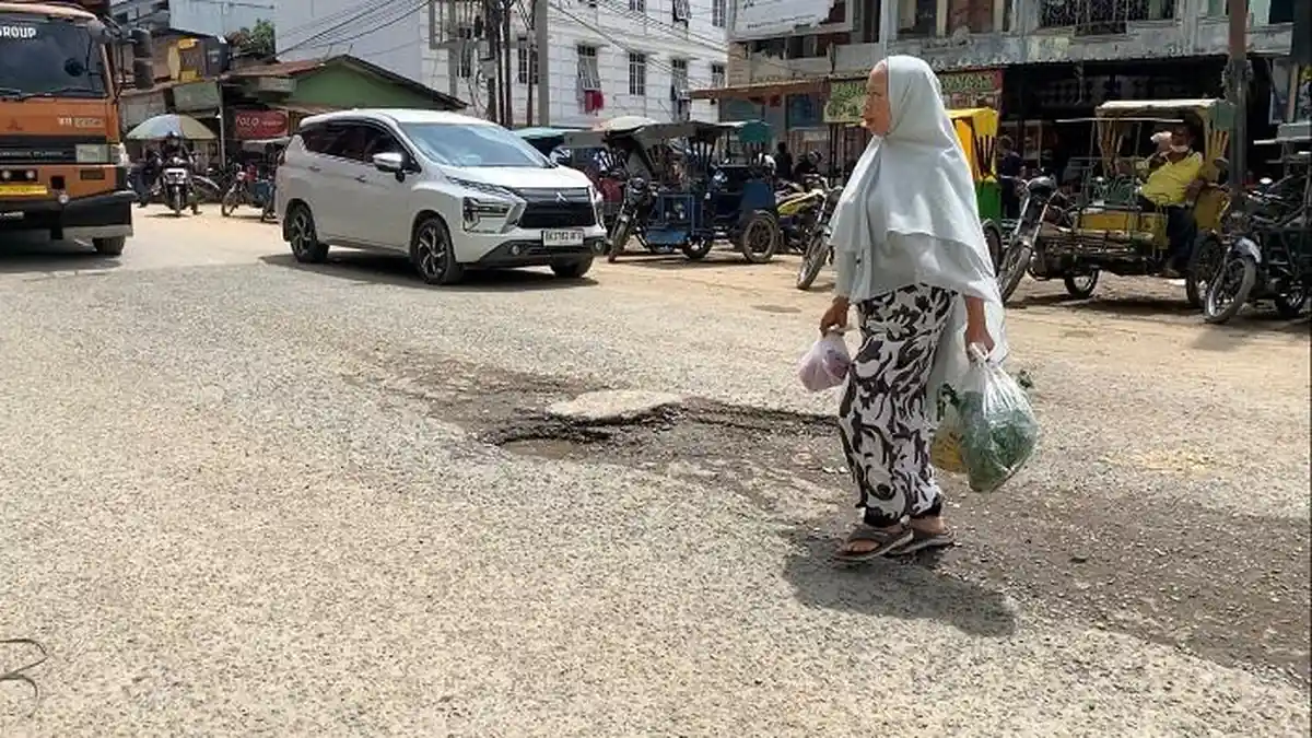 Hati-hati! Ada Lubang di Depan Pasar Pagi Kualasimpang Melebar, Sering Kecelakaan