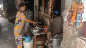 TIDAK-ADIL-Seorang-ibu-memasak-di-depan-kontrakannya-di-permukiman-K.jpg