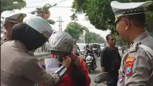 Pihak-kepolisian-dari-Satlantas-Polres-Jombang-saat-memberikan-helm.jpg