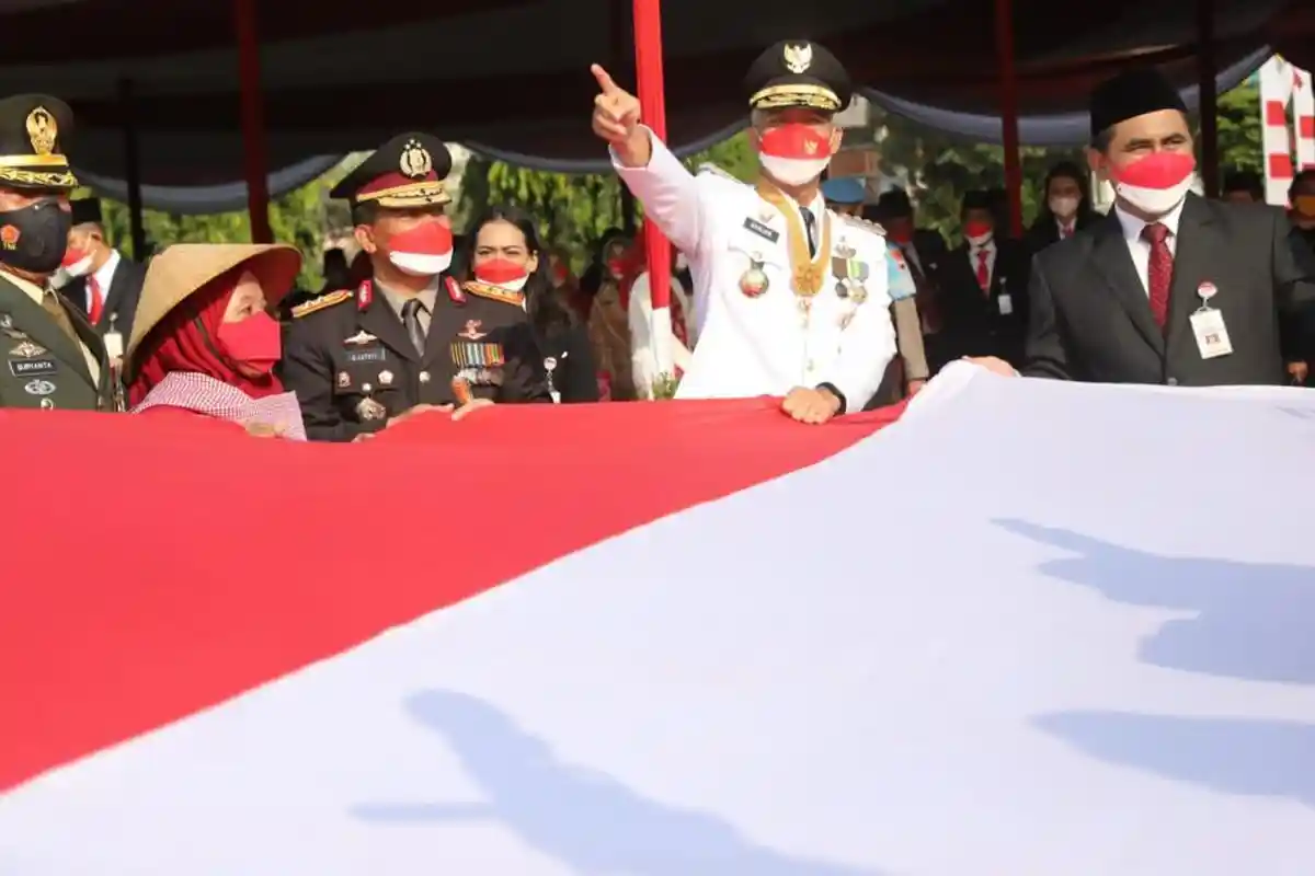 Buruh Migran Berikan Bendera Merah Putih Ukuran Besar ke Ganjar Pranowo saat Upacara HUT ke 77 RI