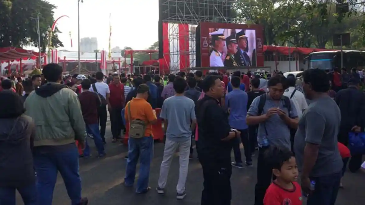 Warga Saksikan Upacara Bendera Dari Layar Lebar di Luar Istana Negara