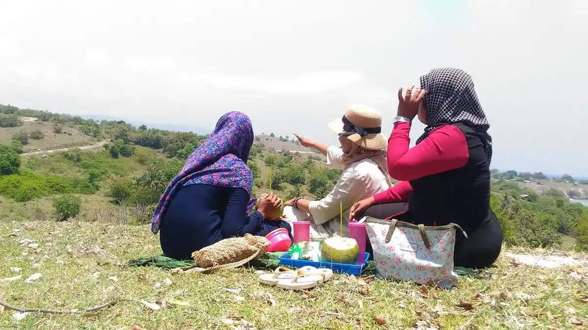 Sembari Minum Kelapa Muda, Wisatawan Ini Memandang Tanjung, Tebing, Pantai Dalam Satu Landscape