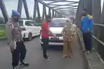 polisi-di-lokasi-kejadian-laporan-palsu-perampokan-uang-rp150-juta-di-jembatan-desa-tanjangrono.jpg