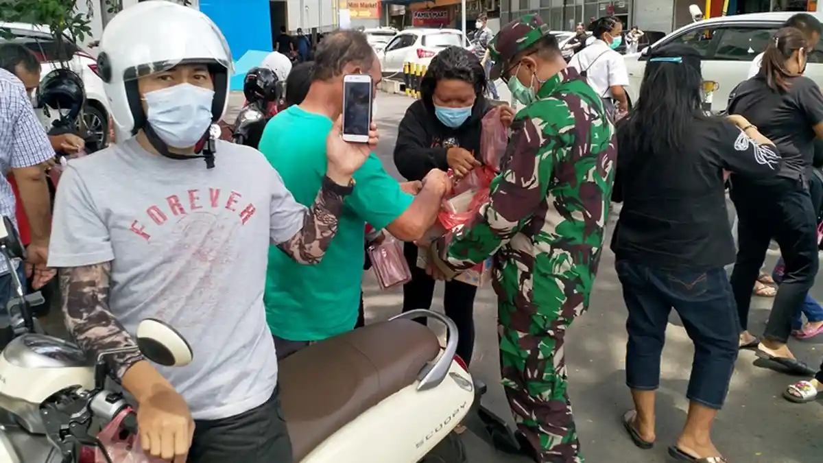 Pengendara dan Pejalan Kaki Jadi Sasaran Bagi-bagi Makanan di Jalan Samrat Manado