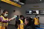 Petugas-thermo-gun-ke-penumpang-pesawat-kedatangan-internasional-bandara.jpg