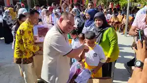 Samaun-Dahlan-menyerahkan-seragam-gratis-kepada-murid-SD.jpg