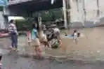 Sejumlah Anak Bermain Air di Genangan Luapan Kali Sabi