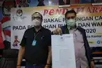 ketua-kpud-karo-gemar-tarigan-st-kanan-menunjukkan-surat-keputusan-penetapan-calon-pilkada-karo.jpg