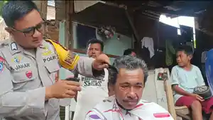 Bhabinkamtibmas-Polsek-Bajeng-Bripka-Aswin-Jahar-saat-mencukur-warga-secara-gratis.jpg