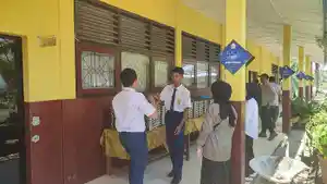 20250217-Siswa-SMPN-7-Tanjungpandan-mengangkat-ompreng-atau-tempat-makan-berisi-menu-MBG.jpg
