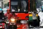 Pemulung dengan Gerobaknya Melintasi Jalan Protokol di Jakarta