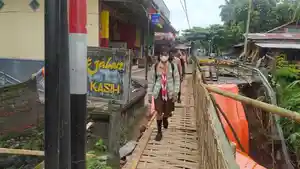 Sejumlah-siswa-saat-melintasi-jembatan-darurat-yang-dibangun-secara-swadaya.jpg