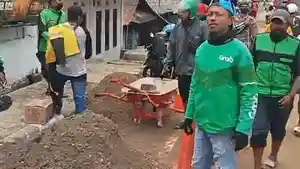 pengemudi-ojol-bersihkan-jalan-turunan-batu-merah.jpg