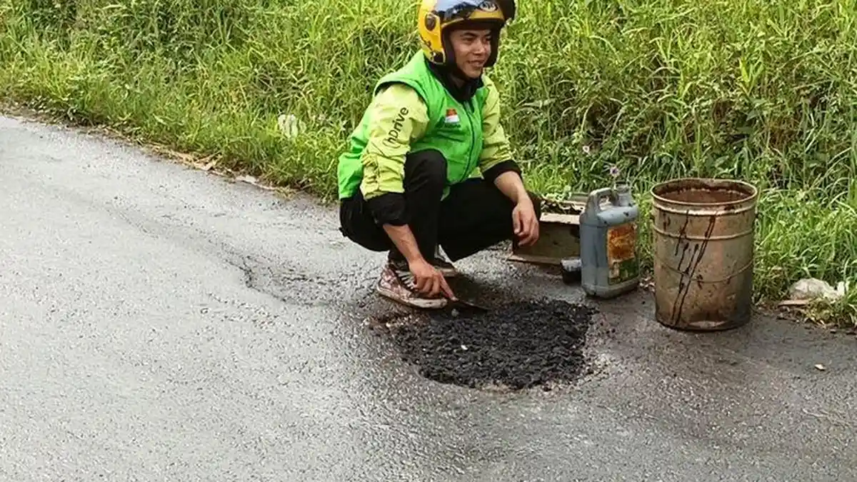 Pengemudi Ojol di Bandung Tambal Jalan dengan Modal Sendiri, Hasan Belajar dari Youtube