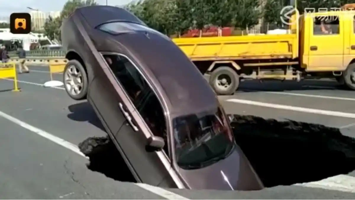 Mendadak Muncul Lubang Besar di Jalan Raya, Pengemudi Kaget, Mobil Mewahnya Terperosok
