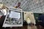 Jemaah Memasukan Uang Infaq ke Kotak Amal